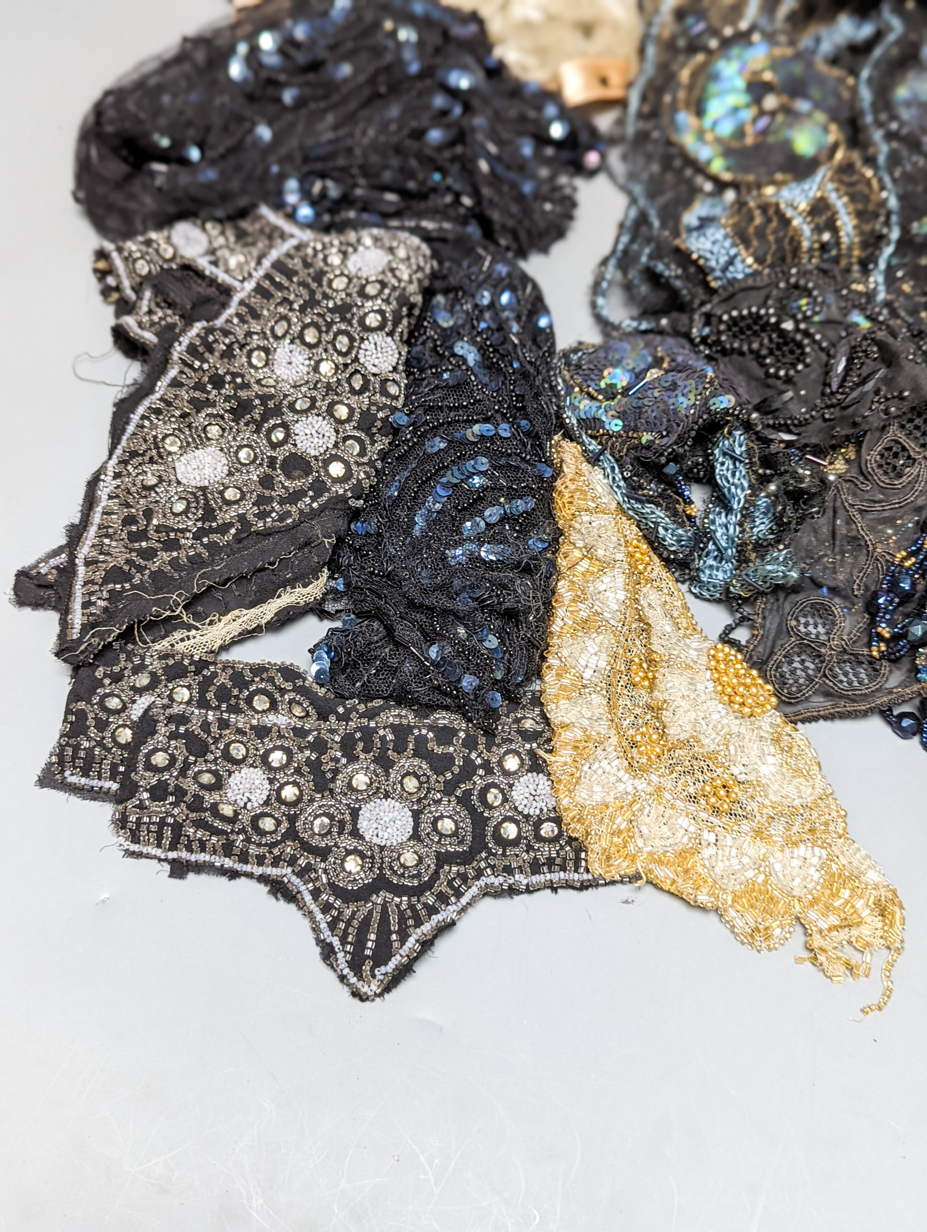 A collection of Edwardian and later sequin and beaded panels on net, a black beaded stole, various buttons etc.